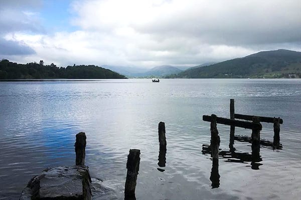 Lone boat on Windermere lake - challenged by park warden (Is the boater reading or fishing?)