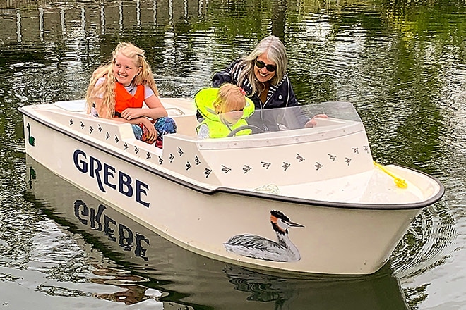 Gillian showing some children the ropes on the lake.