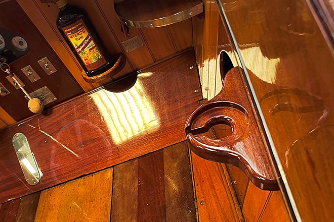 A bespoke folding table including a stand for rum bottles, and glass holders, in mahogany (made by our Ellie).